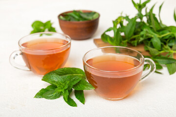 Cup of mint tea on table background. Green tea with fresh mint top view with copy space