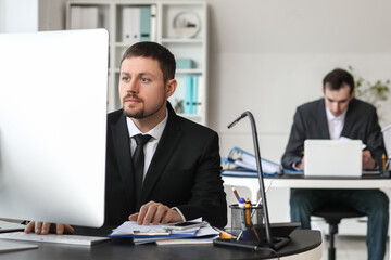 Male accountant working with computer at table in office