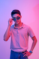 A cocky and brash young asian man wearing shades feeling handsome and cool. Party vibe with blue and red colors.