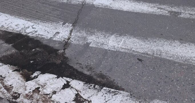 old road markings on the road, pedestrian crossing on an old paved road with damage