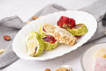 Plate with tasty Turkish delight on light background, closeup
