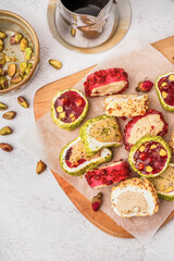 Wooden board with tasty Turkish Delight on light background, closeup