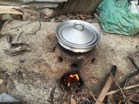 Rural kitchen. Traditional stoves used by residents in rural India, made of clay, fueled with wood, Cooking Food On Soil Stove With Dry Leafs And Wood In Village