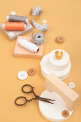 Podiums with tailor's supplies on beige background, closeup