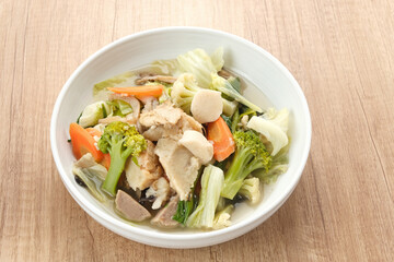 Capcay, stir fried vegetables with shrimp, meatballs and chicken. Served in white plate
