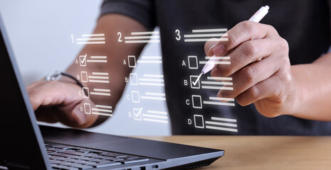 Businessman using laptop to do online checklist survey Take online surveys, digital quizzes, verifications.