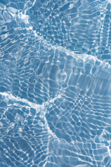 Naklejka premium Blue water with ripples on the surface. Defocus blurred transparent blue colored clear calm water surface texture with splashes and bubbles. Water waves with shining pattern texture background.