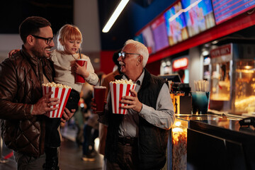 Cheerful grandfather in cinema with children.
