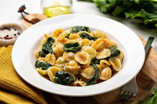 Close-up of Italian pasta Orecchiette con le cime di rapa e le acciughe, Southern Italy dish, typical for Apulia. Made with anchovy, bread crumbs and rapini,  broccoli rabe or turnip greens.