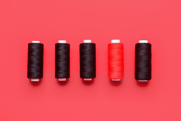 Set of thread spools on red background