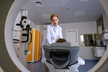 Female doctor conducting mri scan of person, doing tomography, examining patient health