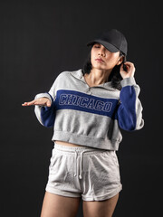 Fototapeta na wymiar A portrait of a casual fashion-style Asian (Chinese Indonesian) Girl posing dan dancing with a Hip hop style. Isolated on a black background