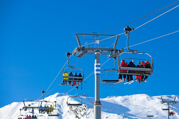 Skiers using the ski lift at Grandvalira ski resort in Pas de la Casa - obrazy, fototapety, plakaty