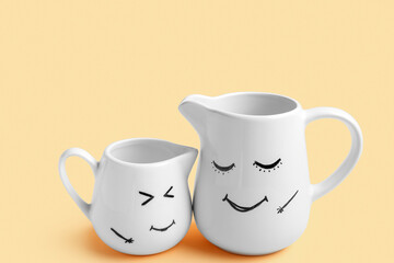Pitchers with happy faces for Friendship Day on beige background