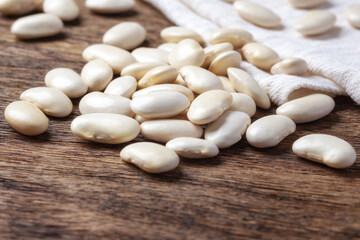 Heap of white beans on wooden table