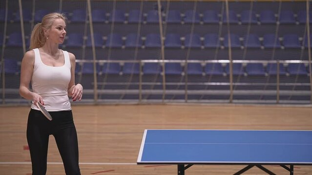 blond woman with big breasts plays table tennis. real time video. High quality Full HD video recording