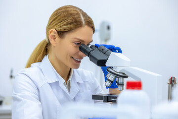 Scientist looking under microscope, doing analysis of test sample ambitious biotechnology specialist