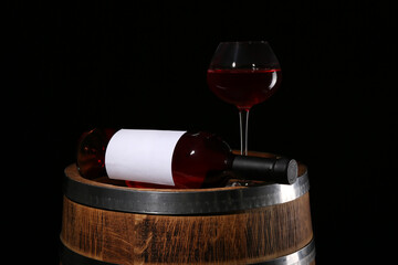Wooden barrel with bottle and glass of wine on dark background