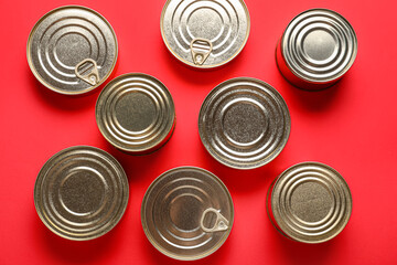 Assortment of tin cans with fish on red background