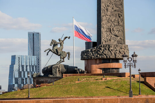 A fragment of the Victory Monument on Pobediteley Square in Victory Park on Poklonnaya Gora. Monument to George the Victorious on the background of the flag of Russia.Tricolour. Moscow. Russia, 2023