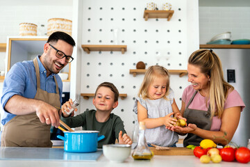Happy family preparing healthy food together in kitchen. People happiness cooking concept