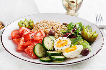 Breakfast oatmeal porridge with boiled eggs, fresh salad and kiwi. Healthy balanced food.