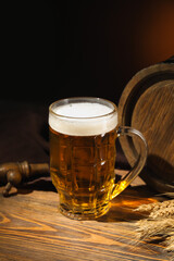 Mug of cold beer on table against dark background