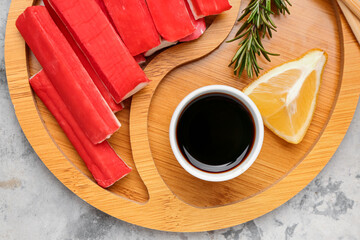 Plate with tasty crab sticks and sauce on grunge background, closeup © Pixel-Shot