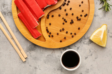 Plate with tasty crab sticks and sauce on grunge background © Pixel-Shot