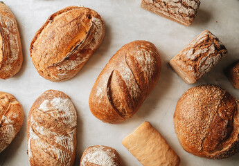 Various kind of bread with wheat top view. White bakery food concept panorama or wide banner photo.