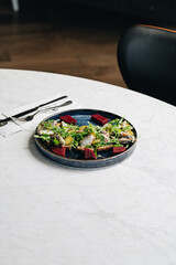 Healthy salad plate with quinoa, tomatoes, chicken, avocado, lime and mixed greens (lettuce, parsley) on wooden background top view. Food and health. Nutritious meal.