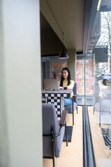 Calm concentrated freelancer using her laptop in a cafe