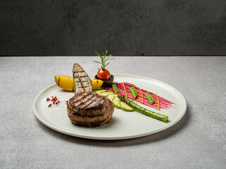 Meat plate prepared on the rich table. Filet mignon, beef steak with grilled vegetables. Ready menu for the restaurant.