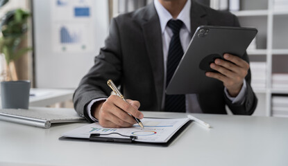 Businessman hand Project manager working and update tasks and Gantt chart scheduling virtual diagram.with tablet and laptop in office.