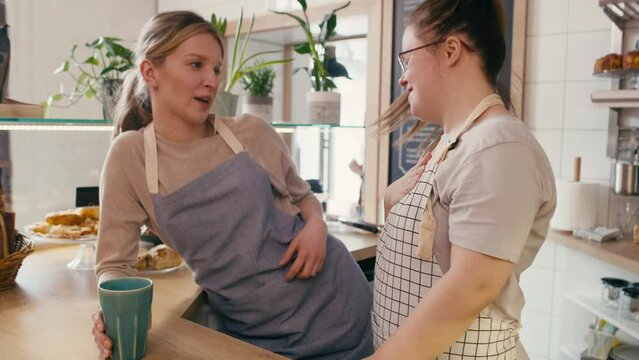 Down syndrome girl chatting with her workmate in the cafe. Shot with RED helium camera in 8K.  
