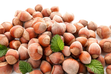 Shelled hazelnuts with leaves on white background