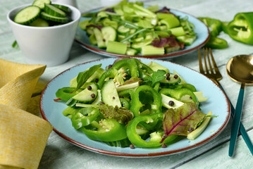 Plates of salad with green vegetables and ingredients on wooden background