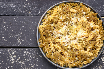 Plate of tasty Italian pasta with Parmesan cheese on dark wooden background