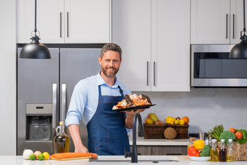 Happy chef in cook apron cooking seafood crab and shrimp, salmon and lobster in kitchen. Cook in...