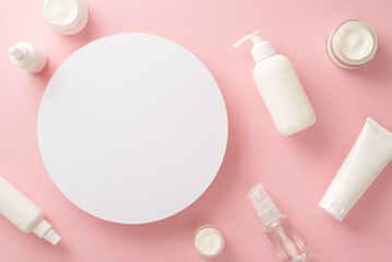 Delicate beauty concept. Top view flat lay of pump bottle, pipette, cream bottles and tubes on pastel pink background with empty circle for text or branding