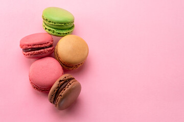 Colorful french macarons isolated on pink background. Top view.