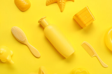 Sunscreen cream for baby with beach accessories on yellow background