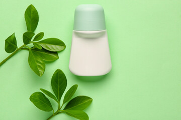 Deodorant with plant twigs on light green background