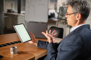 Fototapeta na wymiar Portrait of businessman in office. Man using digital tablet. Businessman having video call..