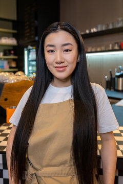 Calm barista posing for the camera in a coffeehouse