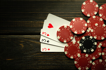 Poker game with three of a kind winning combination. Cards with chips on a black table in a poker club. Copy space