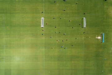 zenithal aerial view of a soccer field during a training session, team sports concept