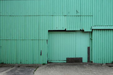 Green corrugated metal barn with closed doors