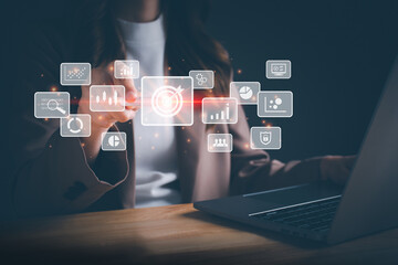 Businesswoman working on laptop and using a stylus pen for big data analytics and business intelligence with chart and graph icons. Goal acheiveement and success concept. Digital screen.