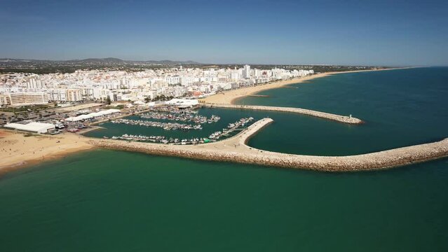 Aerial drone view approaching Quarteira, Algarve, Portugal from the sea, a popular summer resort destination in the south of Portugal